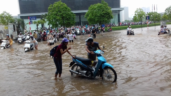 Đường ngập s&acirc;u khiến người d&acirc;n di chuyển qua khu vực Keangnam phải dắt xe men theo c&aacute;c t&ograve;a nh&agrave;.