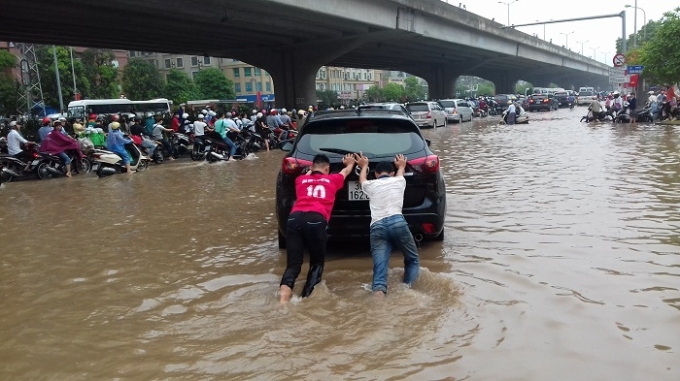 Cố gắng di chuyển chiếc xe &ocirc; t&ocirc; đ&atilde; chết m&aacute;y giữa d&ograve;ng nước.