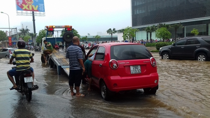 Xe cứu hộ lần lượt di dời những chiếc xe chết m&aacute;y bởi d&ograve;ng nước lũ.