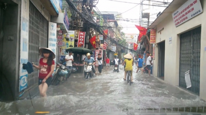 Nhiều người d&acirc;n phải nghỉ l&agrave;m do kh&ocirc;ng thể đưa xe m&aacute;y ra khỏi nh&agrave; v&igrave; nước ngập nặng. (Ảnh: Huy Trung)