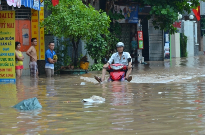 &nbsp;H&igrave;nh ảnh được ghi lại tại Thanh Tr&igrave; H&agrave; Nội, một người đ&agrave;n &ocirc;ng đang cố gắng băng qua d&ograve;ng nước.