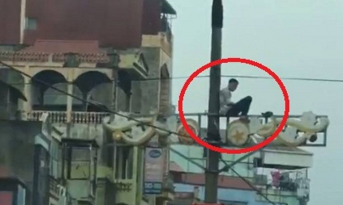 Nam thanh ni&ecirc;n ngồi cố thủ tr&ecirc;n c&acirc;y cột điện.