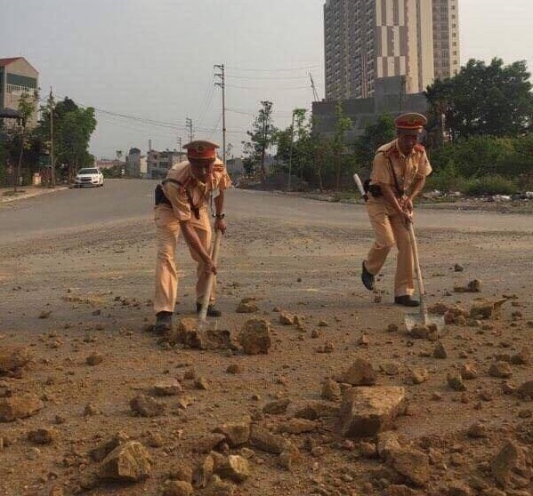 Chiến sĩ cảnh s&aacute;t giao th&ocirc;ng đội 11 tham gia l&agrave;m sạch đường.