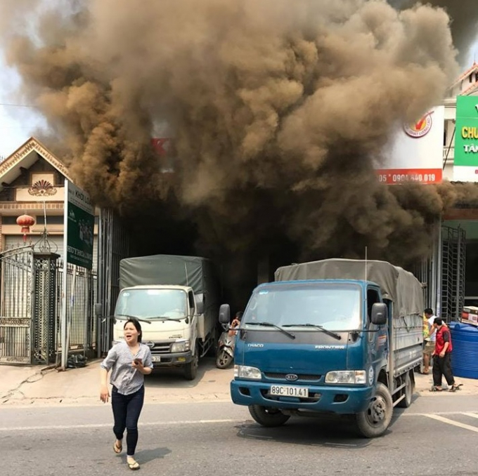 Ngọn lửa b&ugrave;ng ph&aacute;t ra từ kho h&agrave;ng, người d&acirc;n hoảng hốt tho&aacute;t nạn. Ảnh bạn đọc cung cấp.