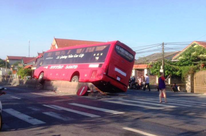 Sau khi va chạm chiếc xe kh&aacute;ch leo l&ecirc;n giải ph&acirc;n c&aacute;ch. Ảnh: Phan Ba