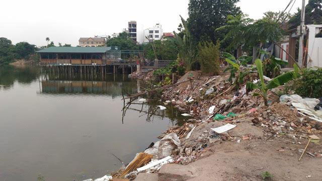 Đống phế thải vật liệu x&acirc;y dựng bị đổ ngay s&aacute;t cạnh khu vực &ocirc;ng Thảo lấn chiếm đ&atilde; &ldquo;ăn&rdquo; v&agrave;o l&ograve;ng hồ đến v&agrave;i m&eacute;t.