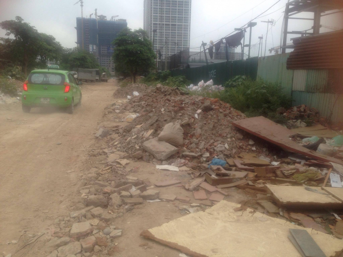 Dọc đường ph&iacute;a b&ecirc;n ngo&agrave;i khu căn hộ ở quận Ho&agrave;ng Mai - H&agrave; Nội t&igrave;nh trạng đổ phế thải x&acirc;y dựng tr&agrave;n ra đường, khiến cho việc giao th&ocirc;ng trở n&ecirc;n nguy hiểm.