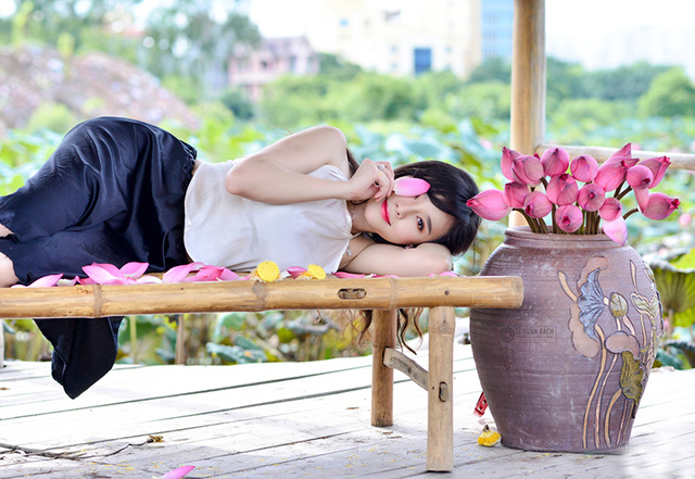 Phần đ&ocirc;ng những người tới chụp ảnh với sen l&agrave; c&aacute;c c&ocirc; g&aacute;i trẻ. C&aacute;c bạn thường chọn trang phục &aacute;o yếm tạo d&aacute;ng b&ecirc;n hoa sen.