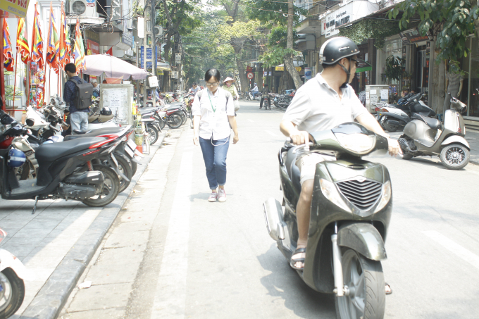 Người đi bộ kh&ocirc;ng c&oacute; vỉa h&egrave; để đi phải đi xuống l&ograve;ng đường.