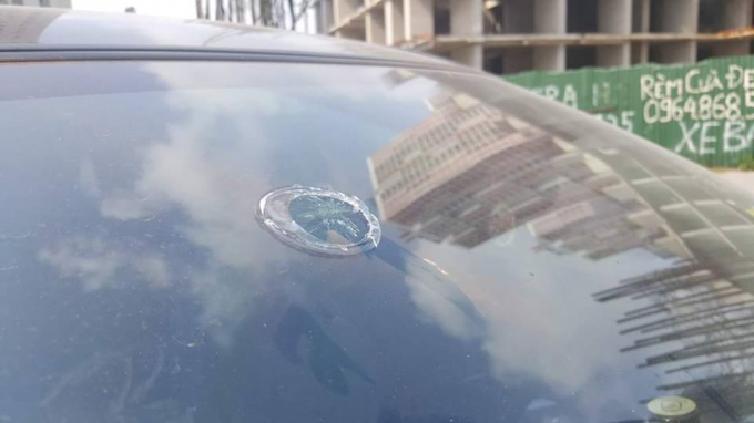 vết nứt lớn ở k&iacute;nh chắn gi&oacute; ph&iacute;a trước &ocirc; t&ocirc; bị gạch rơi ch&uacute;ng