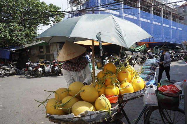 Người b&aacute;n hoa quả trang bị khăn &aacute;o đầy đủ v&agrave; cắm chiếc &ocirc; tr&ecirc;n xe để tr&aacute;nh hỏng hoa quả trong thời tiết khắc nghiệt.