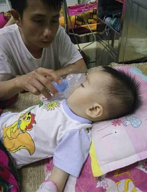 Anh Nguyễn Văn Đ&ocirc;ng b&ecirc;n cạnh đứa con trai mang trong m&igrave;nh căn bệnh hiểm ngh&egrave;o.