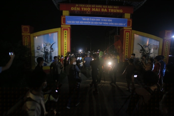 Nhiều người dân tập trung trước cổng vào làng Hạ Lôi nơi thực hiện cách ly phòng dịch COVID-19.