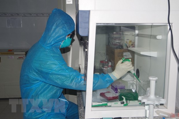 Nhân viên y tế Trung tâm Kiểm soát bệnh tật thực hiện xét nghiệm mẫu bệnh phẩm COVID-19. (Ảnh: Chanh Đa/TTXVN)