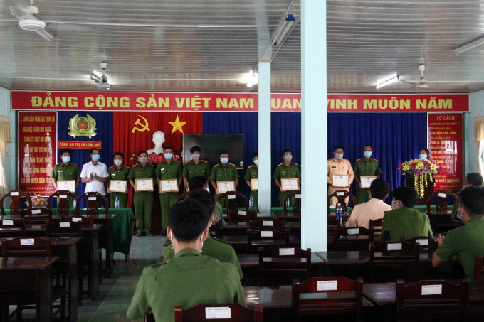 Chủ tịch UBND thị xã Long Mỹ khen thưởng cho các tập thể, cá nhân tham gia truy bắt đối tượng. (Ảnh: Thế Phong)