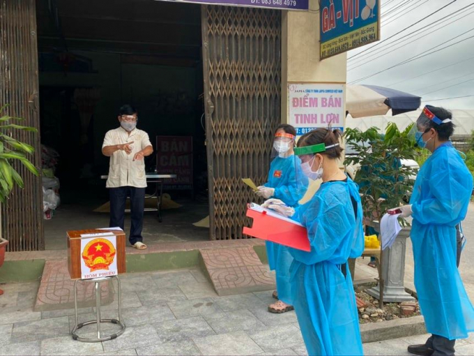 Thành viên tổ bầu cử tại huyện Việt Yên mang hòm phiếu đến hộ gia đình đang bị cách ly để cử tri thực hiện quyền bầu cử.