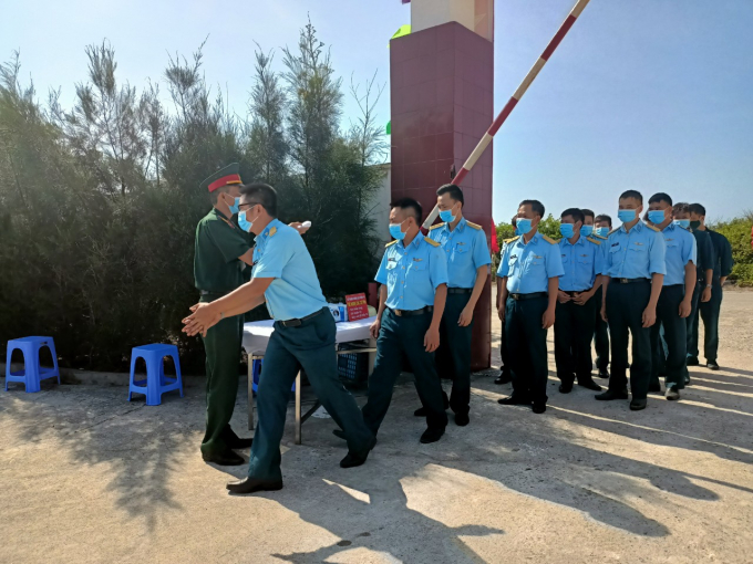 Các cử tri được đo thân nhiệt, sát khuẩn tay trước khi bỏ phiếu.