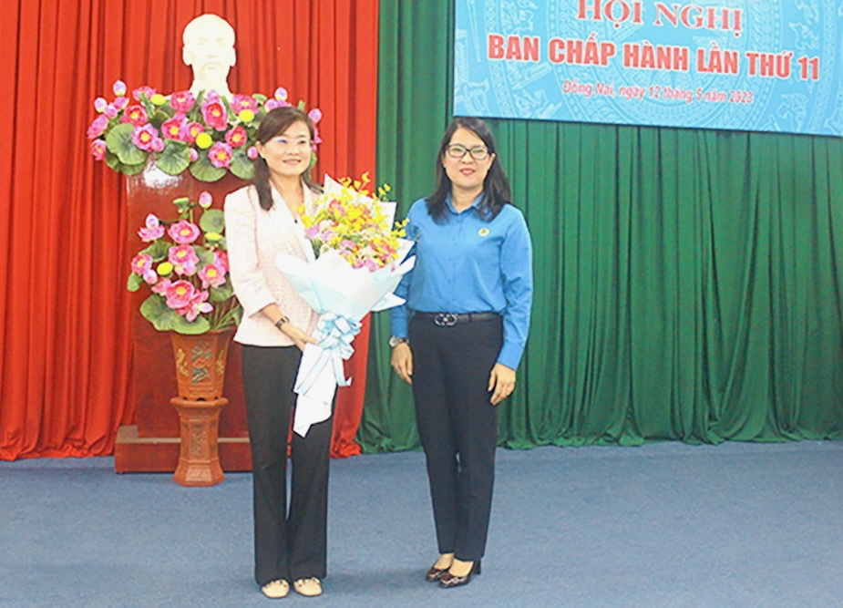 Chủ tịch LĐLĐ tỉnh Đồng Nai Nguyễn Thị Như &Yacute; tặng h&oacute;a ch&uacute;c mừng b&agrave; B&ugrave;i Thị B&iacute;ch Thủy. (b&igrave;a tr&aacute;i - Ảnh: B&aacute;o Đồng Nai)