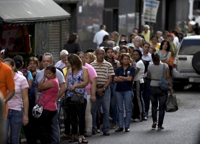 Người d&acirc;n xếp h&agrave;ng chờ mua nhu yếu phẩm b&ecirc;n ngo&agrave;i một si&ecirc;u thị ở thủ đ&ocirc; Caracas. (Ảnh: AP).