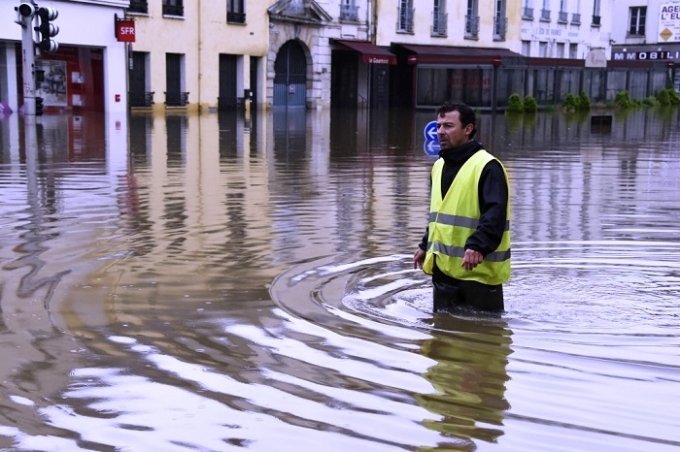 Người d&acirc;n Ph&aacute;p đang vật lộn với cảnh ngập lụt. Ph&aacute;p l&agrave; nơi đăng cai Euro 2016, giải b&oacute;ng đ&aacute; sẽ khai mạc ng&agrave;y 10/6 v&agrave; kết th&uacute;c ng&agrave;y 10/7. Theo ước t&iacute;nh, Euro 2016 sẽ thu h&uacute;t khoảng 2,5 triệu kh&aacute;n giả tới xem tổng cộng 51 trận đấu diễn ra tr&ecirc;n c&aacute;c s&acirc;n cỏ to&agrave;n nước Ph&aacute;p. (Ảnh: AFP).