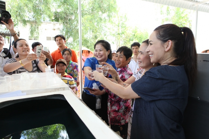 Ca sĩ Phi Nhung c&ugrave;ng đại diện huyện Đo&agrave;n v&agrave; người d&acirc;n tại tỉnh Ki&ecirc;n Giang uống thử nước sau khi lọc.