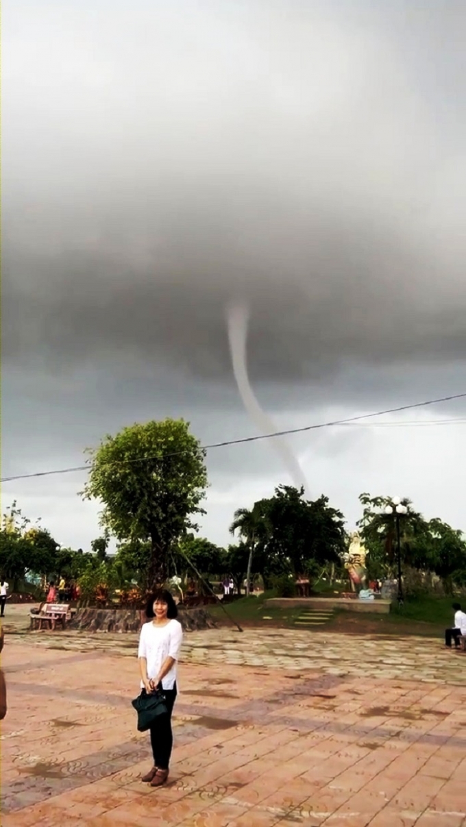 Nữ du kh&aacute;ch đứng chụp ảnh khi thấy v&ograve;i rồng xuất hiện.