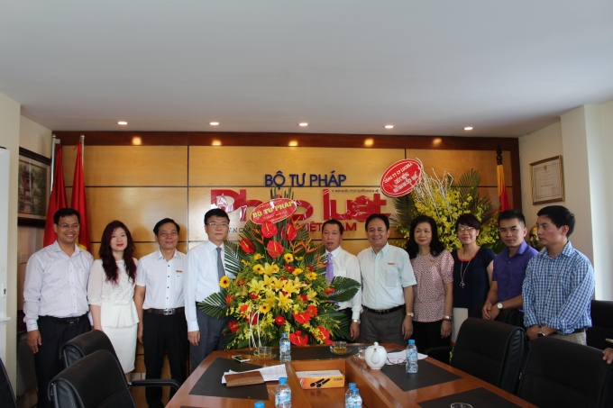 Bộ trưởng tặng hoa l&atilde;nh đạo, ph&oacute;ng vi&ecirc;n B&aacute;o Ph&aacute;p luật Việt Nam.