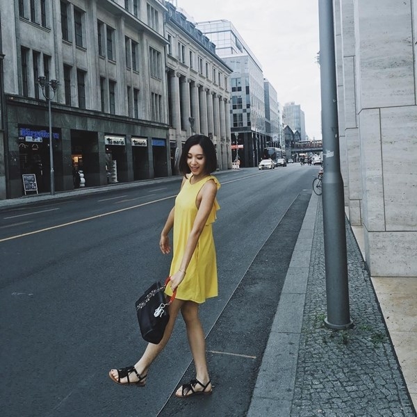 Kh&ocirc;ng bỏ qua xu hướng m&agrave;u sắc đang l&agrave;m c&aacute;c kiều nữ say đắm, Emily chọn đầm v&agrave;ng d&aacute;ng su&ocirc;ng, kết hợp c&ugrave;ng sandals v&agrave; t&uacute;i x&aacute;ch đen t&ocirc;n n&eacute;t trẻ trung, nh&atilde; nhặn.