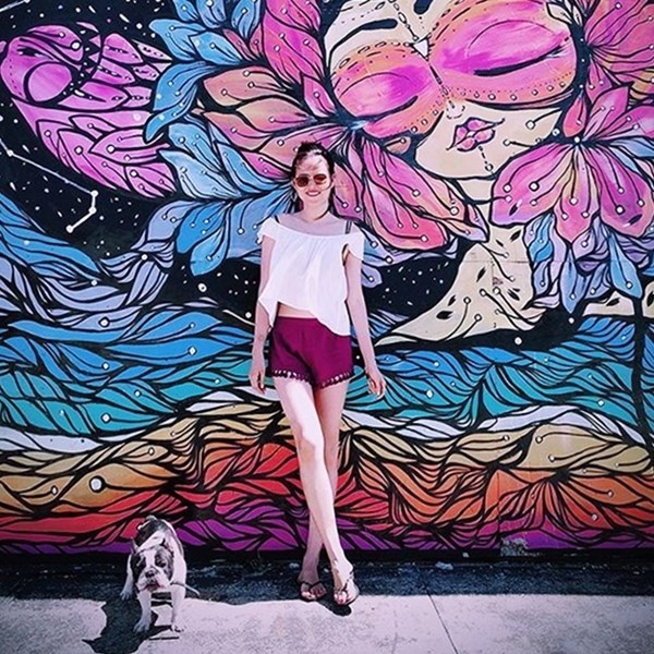 Tuyết Lan tận hưởng m&ugrave;a h&egrave; ngập nắng tại Mỹ với street style khỏe khoắn. N&agrave;ng mẫu 9X mix &aacute;o trễ vai trắng c&ugrave;ng quần shorts đỏ rượu, phối với d&eacute;p xỏ ng&oacute;n v&agrave; k&iacute;nh mắt thời trang.