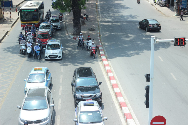 Những người c&oacute; việc phải lưu th&ocirc;ng tr&ecirc;n đường v&agrave;o những ng&agrave;y n&agrave;y tại H&agrave; Nội đều c&oacute; chung cảm gi&aacute;c kh&oacute; chịu, ngộp thở v&agrave; b&oacute;ng r&aacute;t như bị tạt lửa v&agrave;o người. Tr&ecirc;n nhiều tuyến đường, người d&acirc;n tranh thủ đứng chờ đ&egrave;n đỏ dưới những t&aacute;n c&acirc;y xanh để &ldquo;giảm nhiệt&rdquo;.