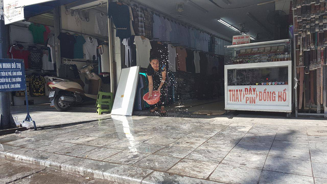 Tr&ecirc;n phố H&agrave;ng Ngang, c&aacute;c chủ cửa h&agrave;ng phải li&ecirc;n tục tạt nước để