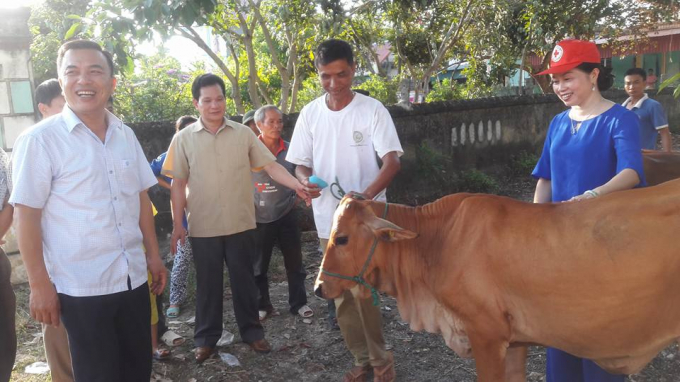 &Ocirc;ng&nbsp;B&ugrave;i Sỹ Lợi (thứ 2 từ tr&aacute;i sang) hỗ trợ 6 con b&ograve; sinh sản cho c&aacute;c hộ gia đ&igrave;nh c&oacute; ho&agrave;n cảnh kh&oacute; khăn x&atilde; Quảng T&acirc;n. Ảnh: Nguyet Trinh