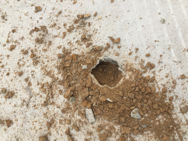 Chọc nhẹ thủng lớp b&ecirc; t&ocirc;ng dầy 2 cm th&igrave; lộ ra đất v&agrave; c&aacute;t ph&iacute;a dưới.