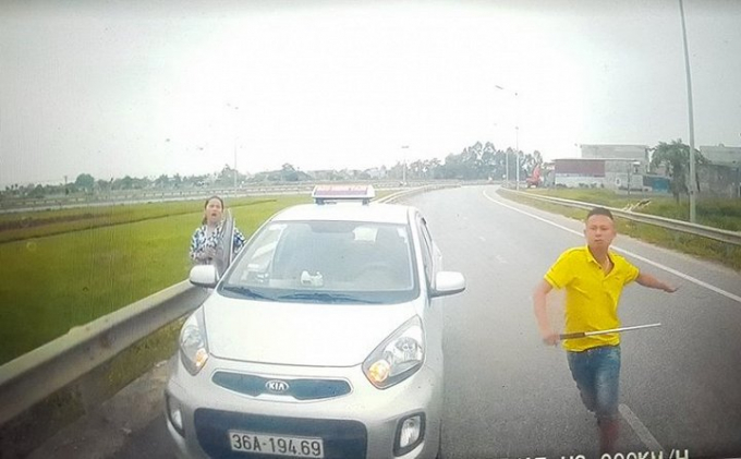 Kh&ocirc;ng được nhường đường, thanh ni&ecirc;n n&agrave;y c&ograve;n mở cửa xe v&agrave; r&uacute;t tu&yacute;p sắt đ&ograve;i xử t&agrave;i xế. (Ảnh: cắt từ clip)