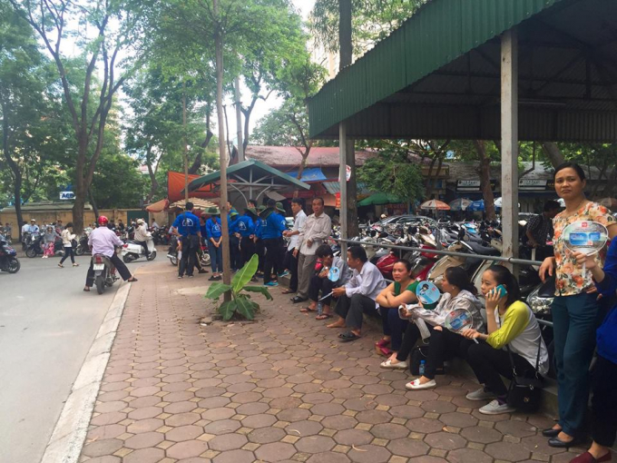 Phụ huynh th&iacute; sinh được c&aacute;c bạn t&igrave;nh nguyện vi&ecirc;n ph&aacute;t quạt, tặng nước tiếp sức m&ugrave;a thi.