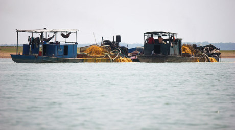 Ghe khai th&aacute;c c&aacute;t hoạt động trong l&ograve;ng hồ Dầu Tiếng.