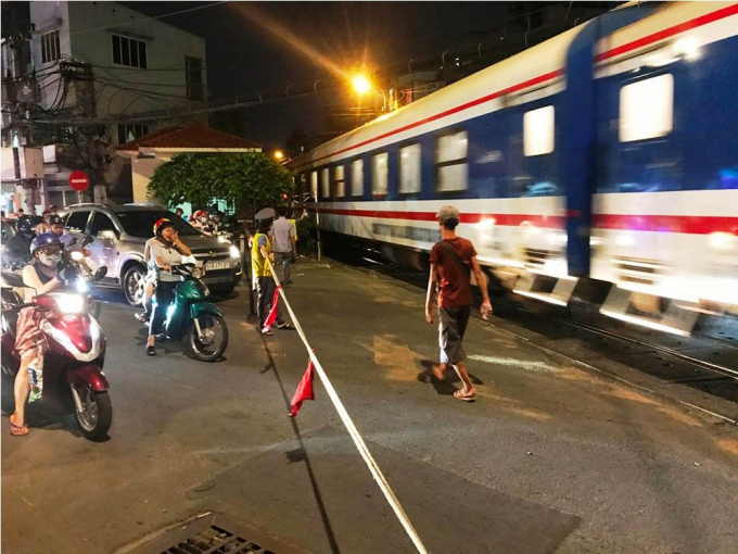 Nh&acirc;n vi&ecirc;n g&aacute;c t&agrave;u phải giăng d&acirc;y thay thanh chắn vừa bị &ocirc; t&ocirc; hạ gục để điều tiết giao th&ocirc;ng khi c&oacute; t&agrave;u lửa chạy qua.