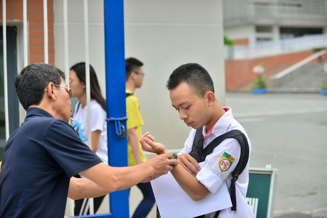 Phụ huynh chăm ch&uacute;t cho con trước khi v&agrave;o ph&ograve;ng thi m&ocirc;n Ngữ Văn, ảnh chụp tại điểm thi Trường THPT Chuy&ecirc;n H&agrave; Nội - Amsterdam s&aacute;ng 25/6/2018. (Ảnh: To&agrave;n Vũ)