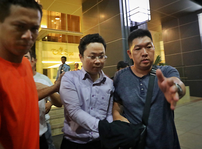 Lâm Hoàng Tùng (kính trắng) bị đưa về cơ quan điều tra.