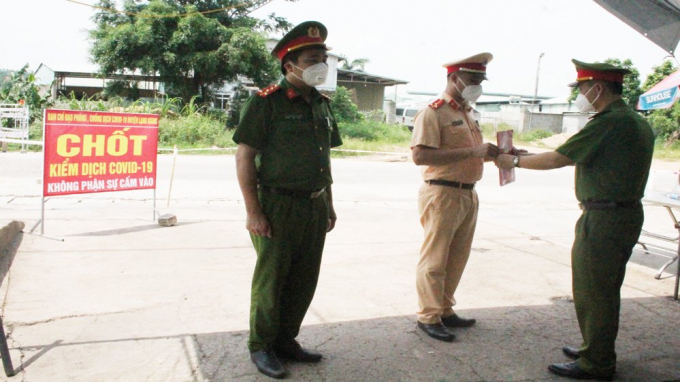 Đại úy Nguyễn Văn Thanh, Đội hình sự và Thượng úy Lưu Xuân Đức, Đội giao thông (Công an huyện Lạng Giang) rưng rưng khi được đồng đội trao quyết định thăng hàm tại chốt kiểm soát dịch. (ẢNh: Bá Đoàn)