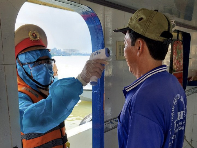 Dưới trời nắng oi bức, nhưng những c&aacute;n bộ, chiến sỹ Cảnh s&aacute;t giao th&ocirc;ng trong trang phục bảo hộ k&iacute;n m&iacute;t, nhẹ nh&agrave;ng hướng dẫn c&aacute;c t&agrave;u, thuyền v&agrave;o kiểm tra, tuy&ecirc;n truyền ph&ograve;ng, chống dịch bệnh Covid 19. 