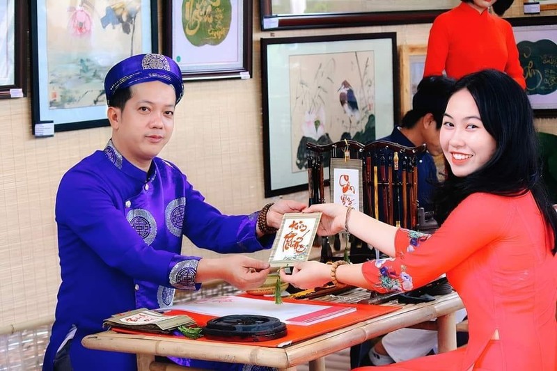 Phi Long tặng chữ thư ph&aacute;p cho kh&aacute;ch tham quan.