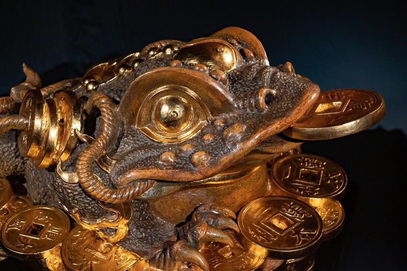 Kim Thiềm Thừ cơ bản vẫn được ngồi trên một đống thỏi tiền vàng, trên miệng ngậm một thỏi tiền, trên lưng và đằng sau có 2 xâu tiền vàng.