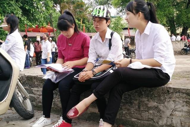 Th&iacute; sinh đến điểm thi sớm, tranh thủ &ocirc;n b&agrave;i trước giờ thi m&ocirc;n đầu ti&ecirc;n (ảnh: Th&aacute;i B&aacute;).