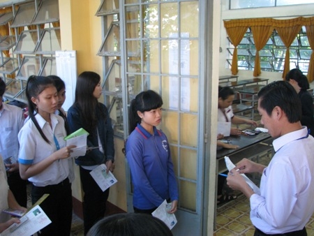 Gi&aacute;m thị gọi th&iacute; sinh v&agrave;o ph&ograve;ng thi v&agrave; kiểm tra rất kỹ giấy tờ của c&aacute;c em. (Ảnh: Huỳnh Hải)
