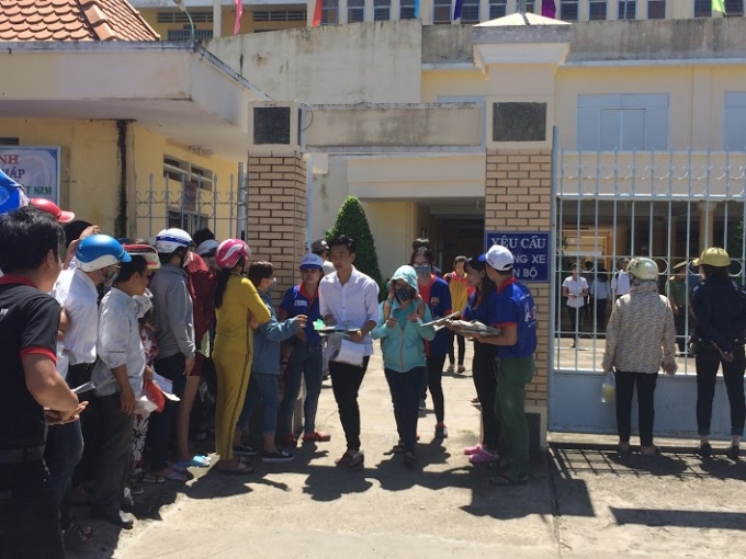 C&aacute;c t&igrave;nh nguyện vi&ecirc;n ph&aacute;t tờ rơi v&agrave; cơm chay miễn phi cho th&iacute; sinh.