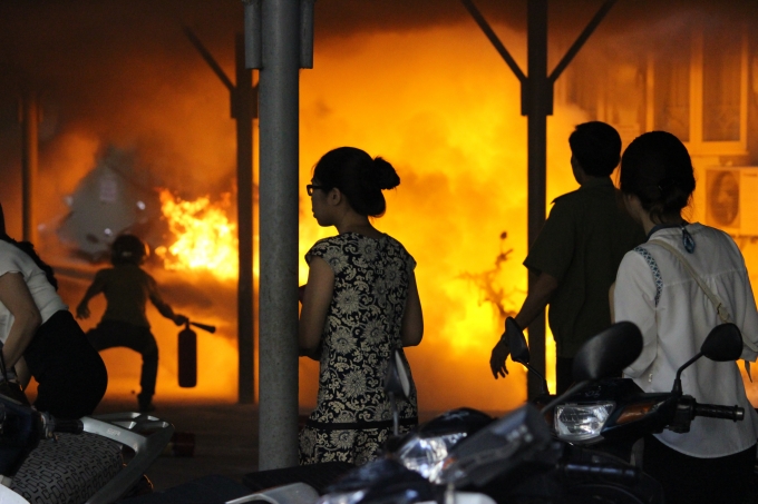 Bảo vệ nh&agrave; trường d&ugrave;ng b&igrave;nh chữa ch&aacute;y tại chỗ khống chế ngọn lữa nhưng bất th&agrave;nh