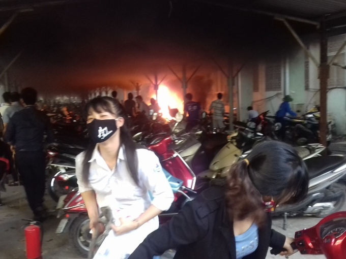 Phụ huynh và thí sinh đang cố gắng di chuyển chiếc xe của mình ra khỏi khu vực cháy.