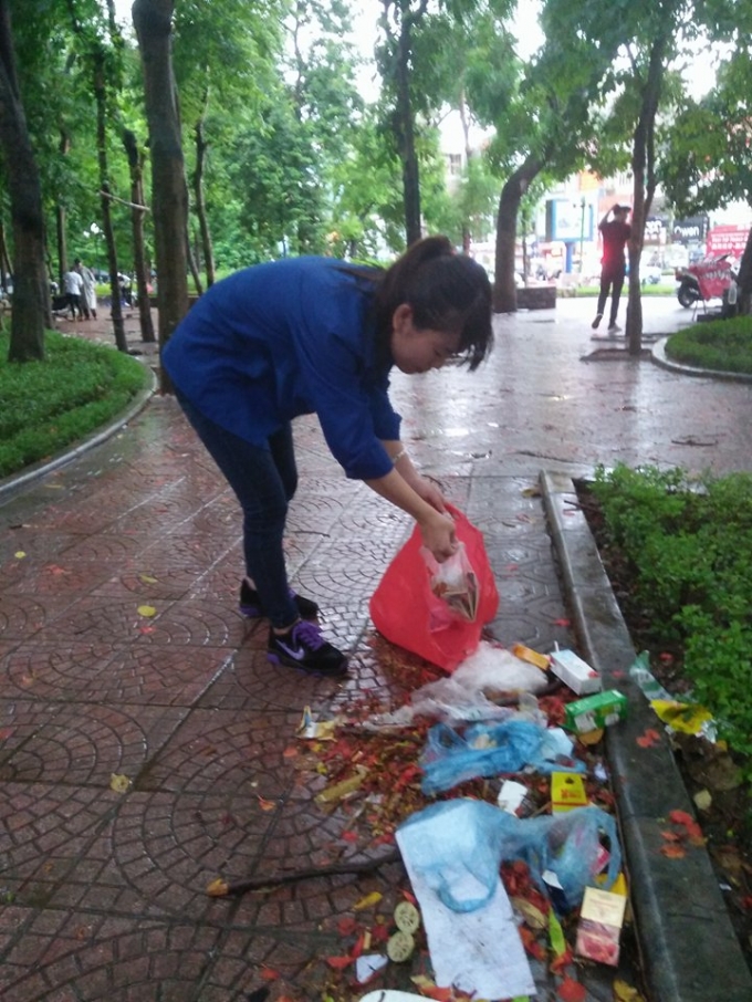 Thanh Hương, bạn t&igrave;nh nguyện vi&ecirc;n tại điểm thi Đại Học Thủy Lợi gi&uacute;p c&aacute;c c&ocirc; lao c&ocirc;ng thu dọn r&aacute;c sau ng&agrave;y thi thứ 2. Ảnh: Trần Quang