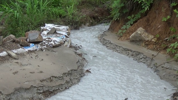 Nước thải xả ra c&oacute; m&agrave;u trắng đục, khu vực đất xung quanh miệng ống xả c&oacute; m&agrave;u trắng x&aacute;m, lắng cặn v&agrave; c&oacute; m&ugrave;i nồng kh&oacute; chịu - Ảnh Huy Trung